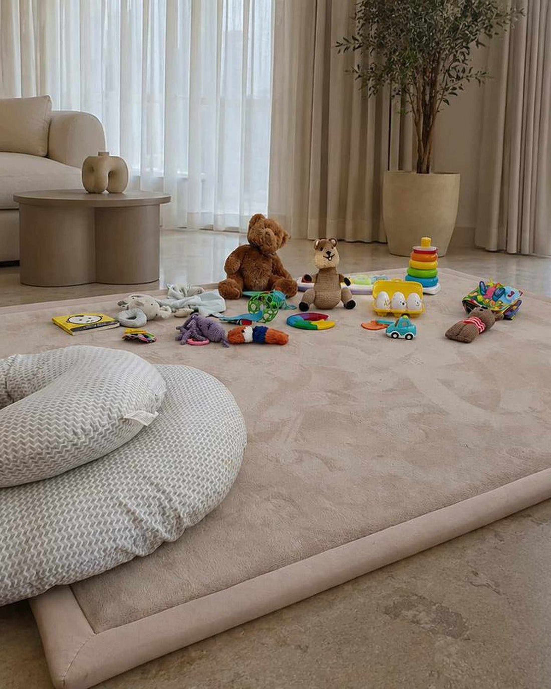 Baby play mat in a neutral living room with toys on a beige Misk Mat memory foam mat