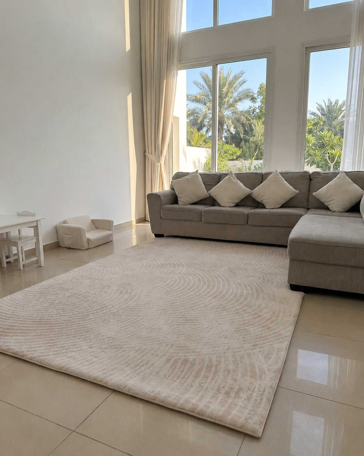 Misk Mat Ivory Arches 35mm memory foam mat with an embossed arch pattern in a bright living room with a grey sofa and garden view.