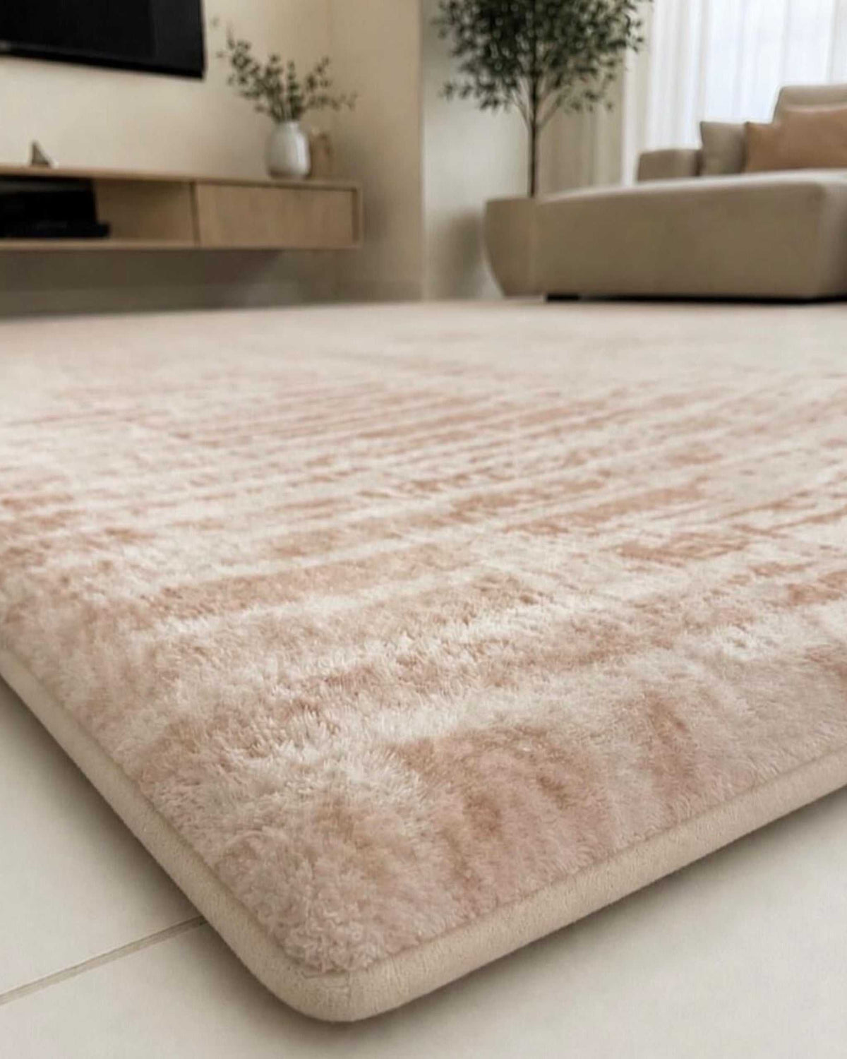 Close-up of the Misk Mat Ivory Arches 35mm memory foam surface, showing the soft blush arch pattern in a living room setting.