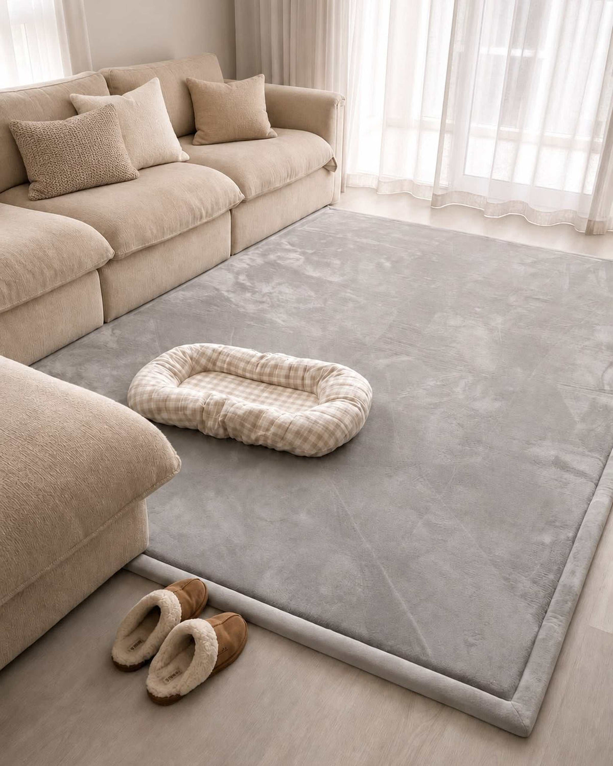 Light Grey Misk Mat 35mm memory foam mat in a living room with a beige sofa, pet bed and a pair of slippers.