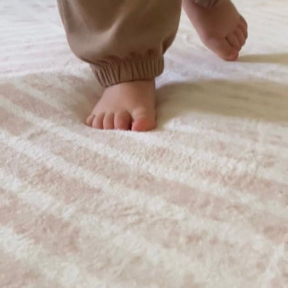 Ivory Arches patterned memory foam mat with a toddlers feet sinking into it showing its cushioning and 35mm thickness