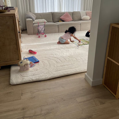 Vanilla Cream faux fur memory foam mat, set up in a living room with kids building a puzzle on it