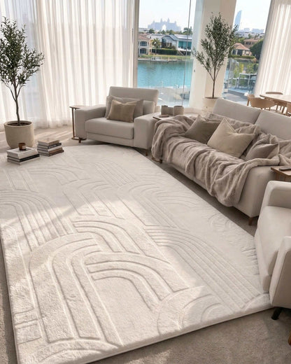 Misk Mat Vanilla Cream 35mm memory foam mat with a raised arch pattern in a bright living room, styled with a sofa, armchair and waterfront view.